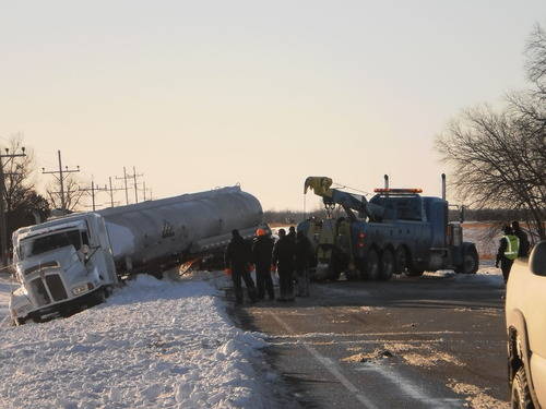 Crews work to remote the flipped semi from Highway 166