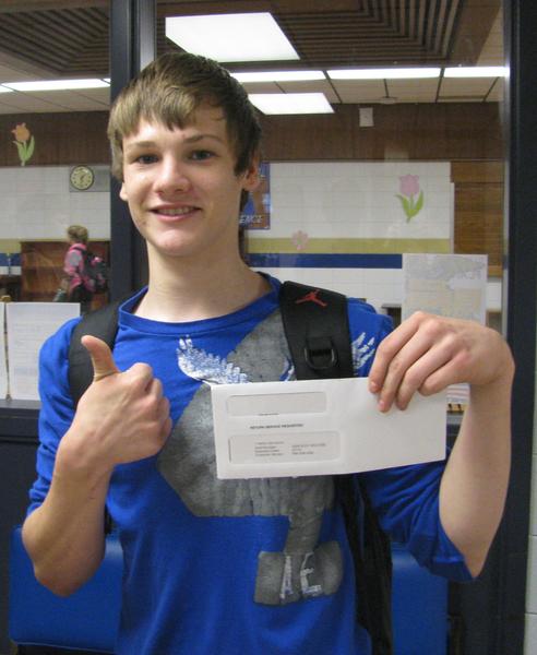 Male student recipient holding his award envelope giving a thumbs up sign