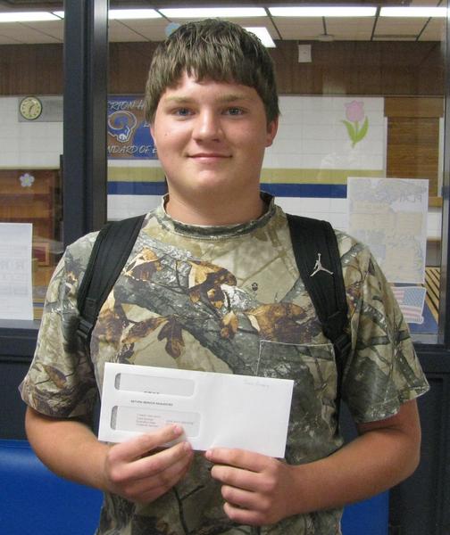 Male student recipient holding award envelope wearing camo t-shirt