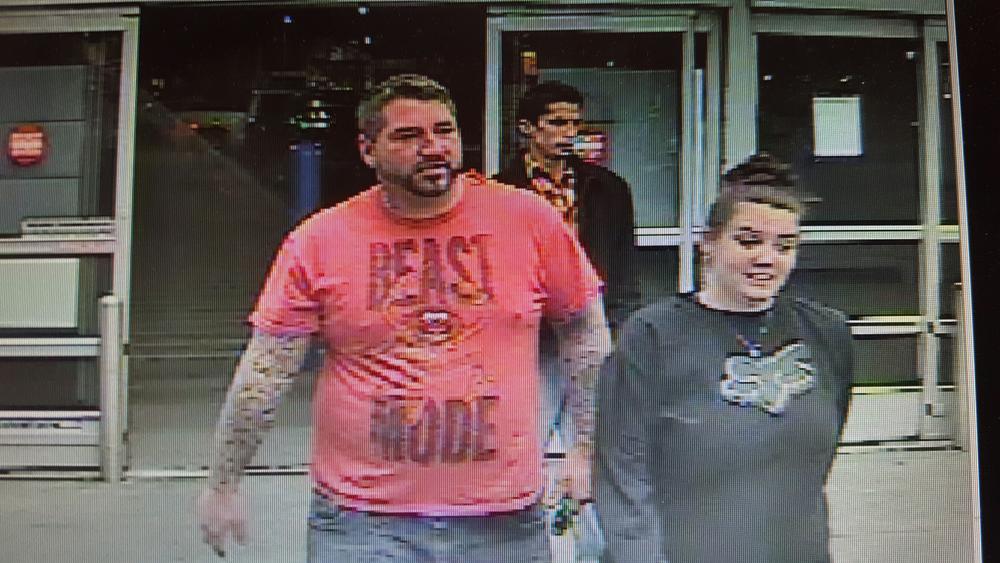 security camera image of man and woman leaving store - man wearing a red shirt that says Beast Mode and woman's shirt has Fox logo
