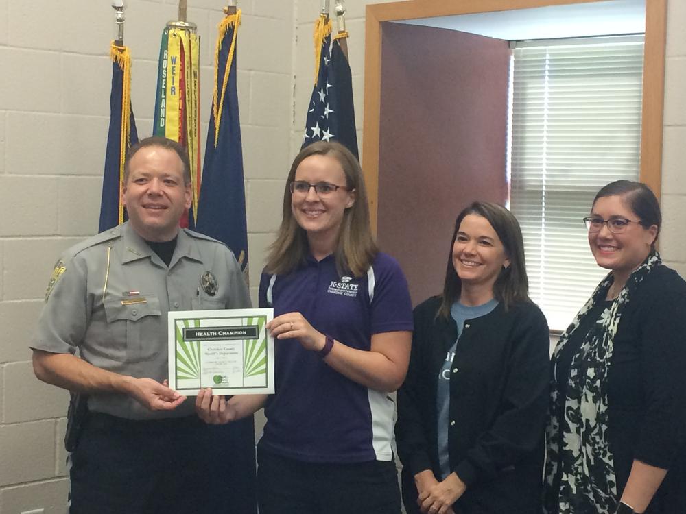 Sheriff David Groves, Christina Holmes, Teresa Cassidy and Tiffany Green standing and smiling with award