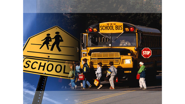 School bus with students crossing in front of it, plus school crossing sign